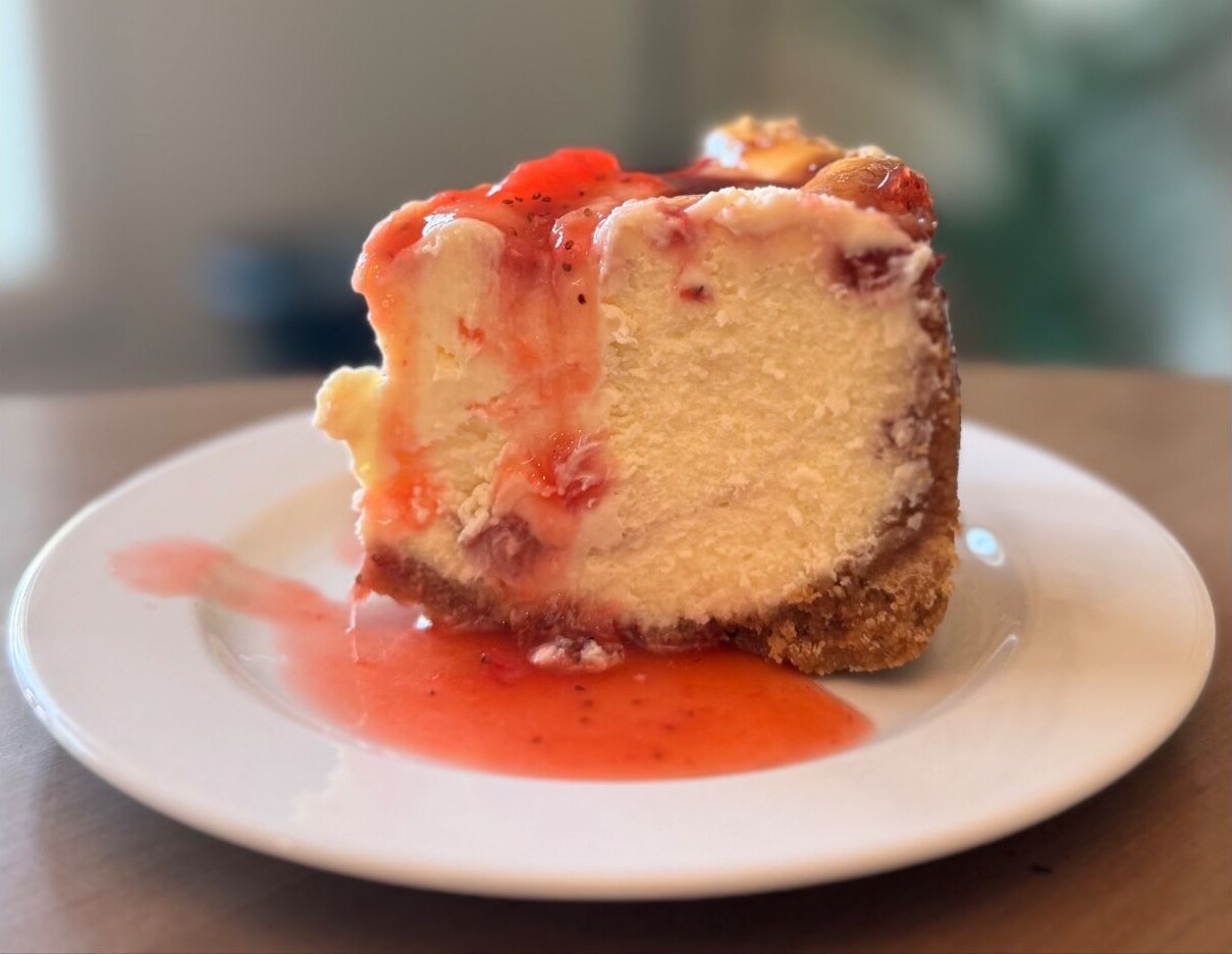A slice of homemade strawberry swirl cheesecake